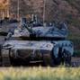 Israeli soldiers work on their tank near the Israel-Gaza border