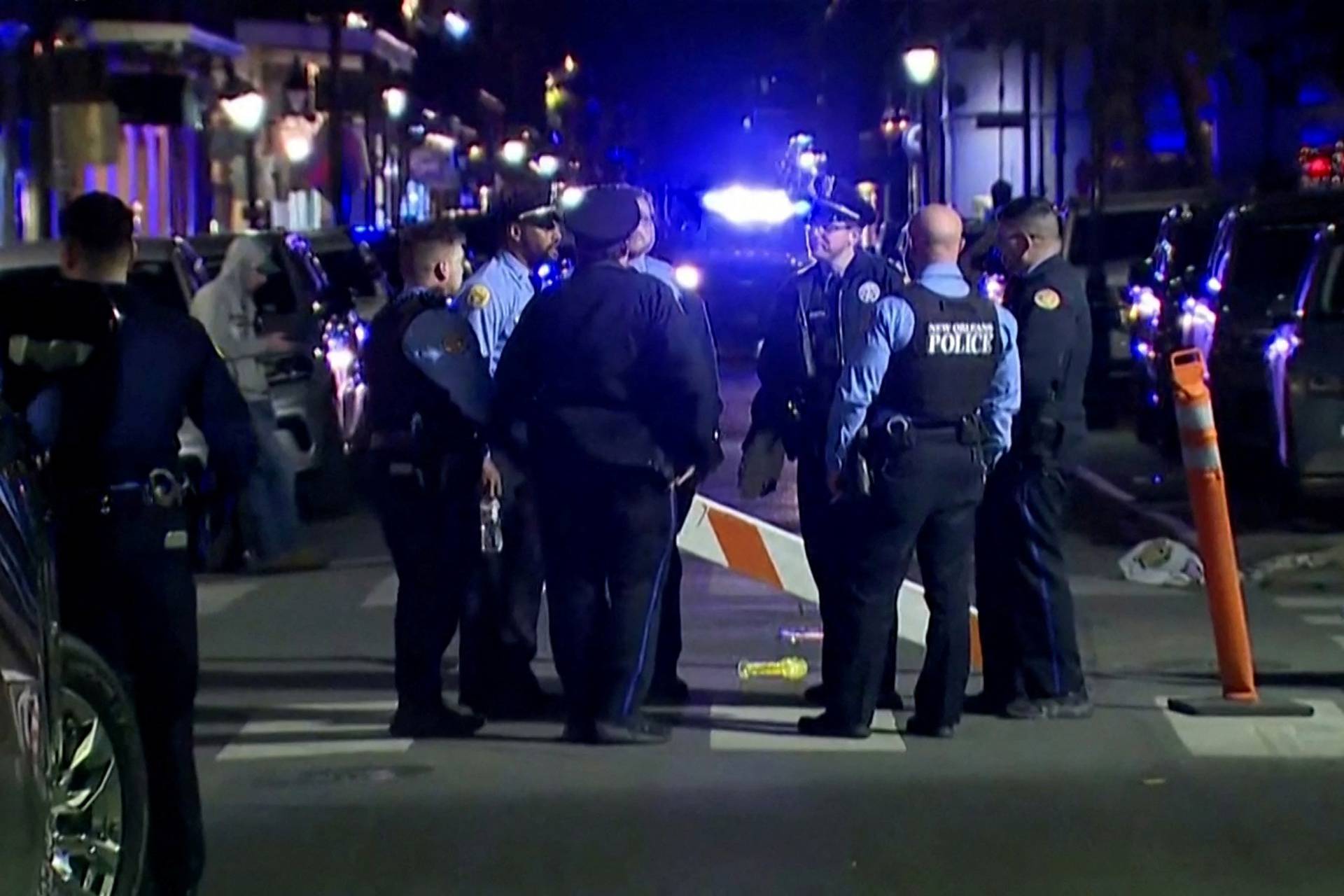 Police officers stand at the scene where a truck drove into a large crowd on Bourbon Street in New Orleans