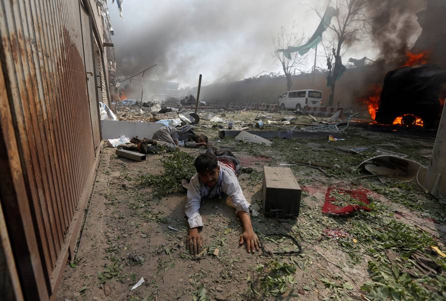 A wounded man lies on the ground at the site of a blast in Kabul, Afghanistan