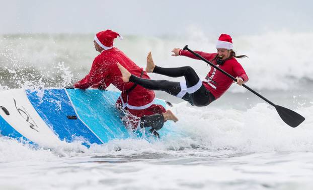 Surfing Santas take to the waves at the annual Christmas Eve event in Cocoa Beach