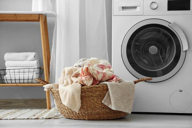 Wicker,Basket,With,Dirty,Clothes,Near,Washing,Machine,In,Laundry