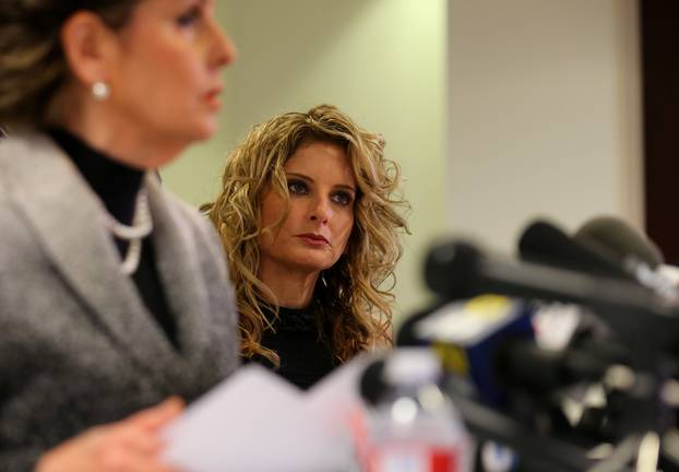 Summer Zervos listens as her attorney Gloria Allred speaks during a news conference announcing the filing of a lawsuit against President-elect Donald Trump in Los Angeles