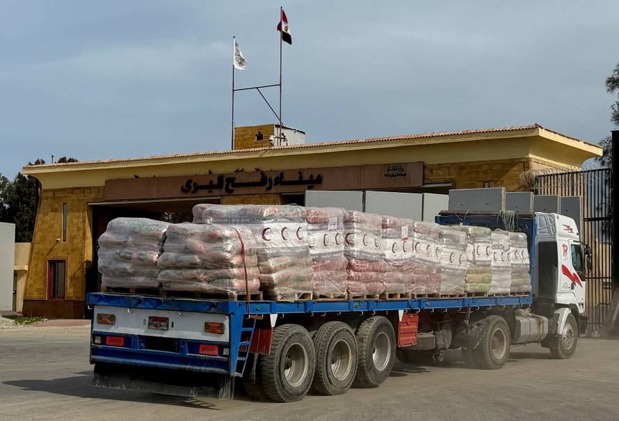 Trucks carrying humanitarian aid and fuel line up at the Rafah border to cross into the Gaza Strip, on the Egyptian side, in Rafah