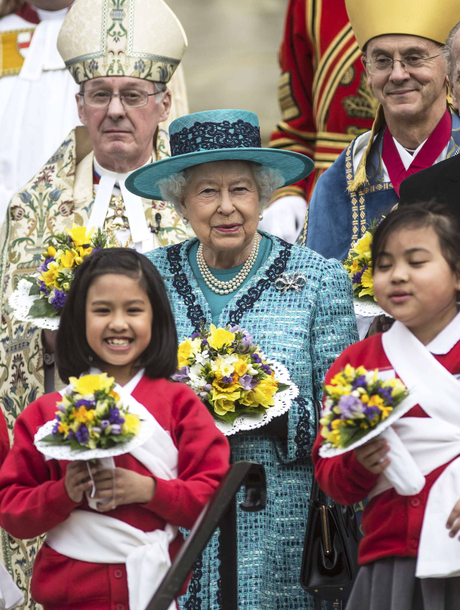 Britain's Queen Elizabeth and Prince Philip pose with Yeomen of the Guard and schoolchildren after attending a Maundy Thursday service at St George's Chapel in Windsor 