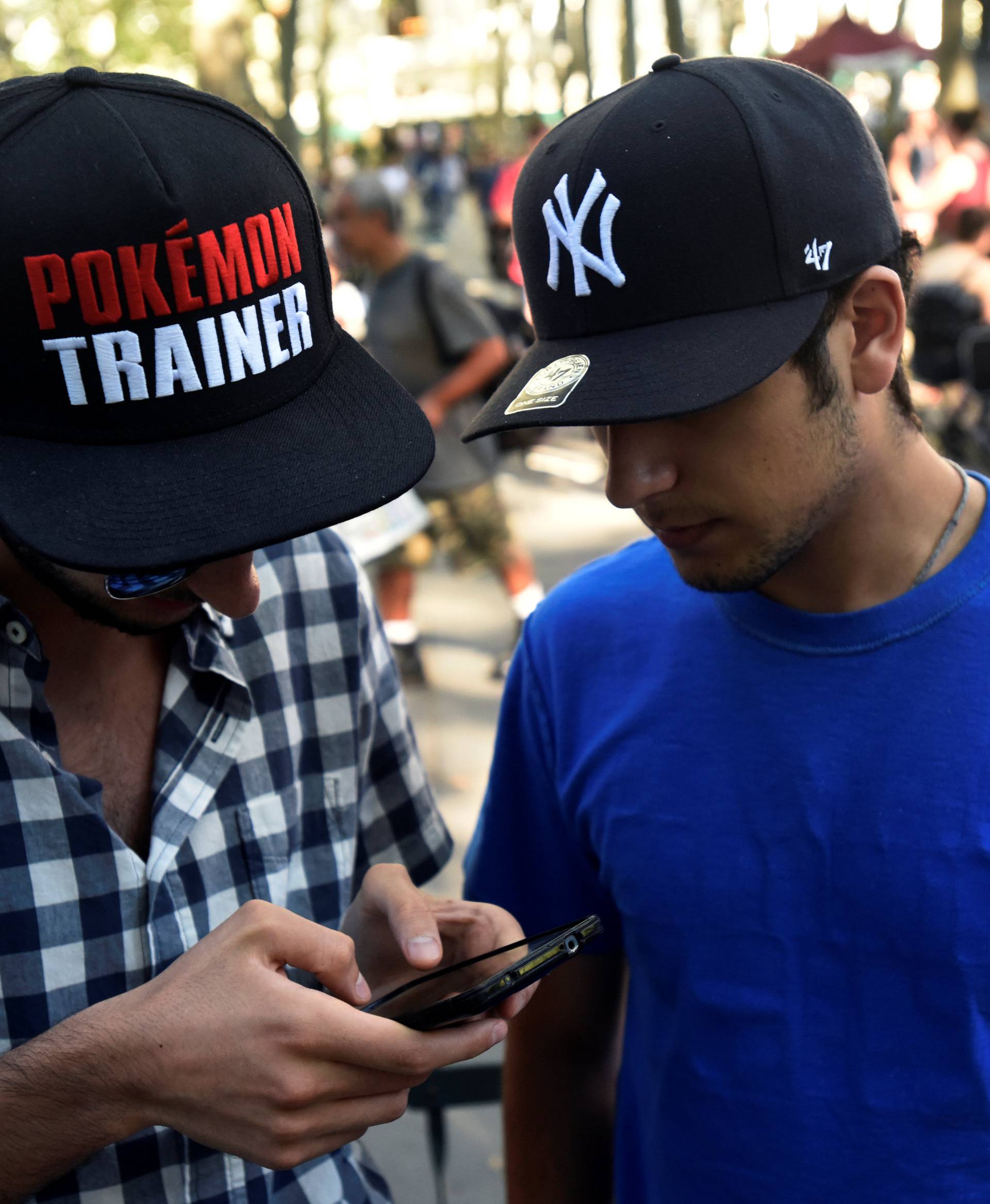 A man wears a Pokemon-themed hat as he plays the augmented reality mobile game "Pokemon Go" by Nintendo in Bryant Park, New York City