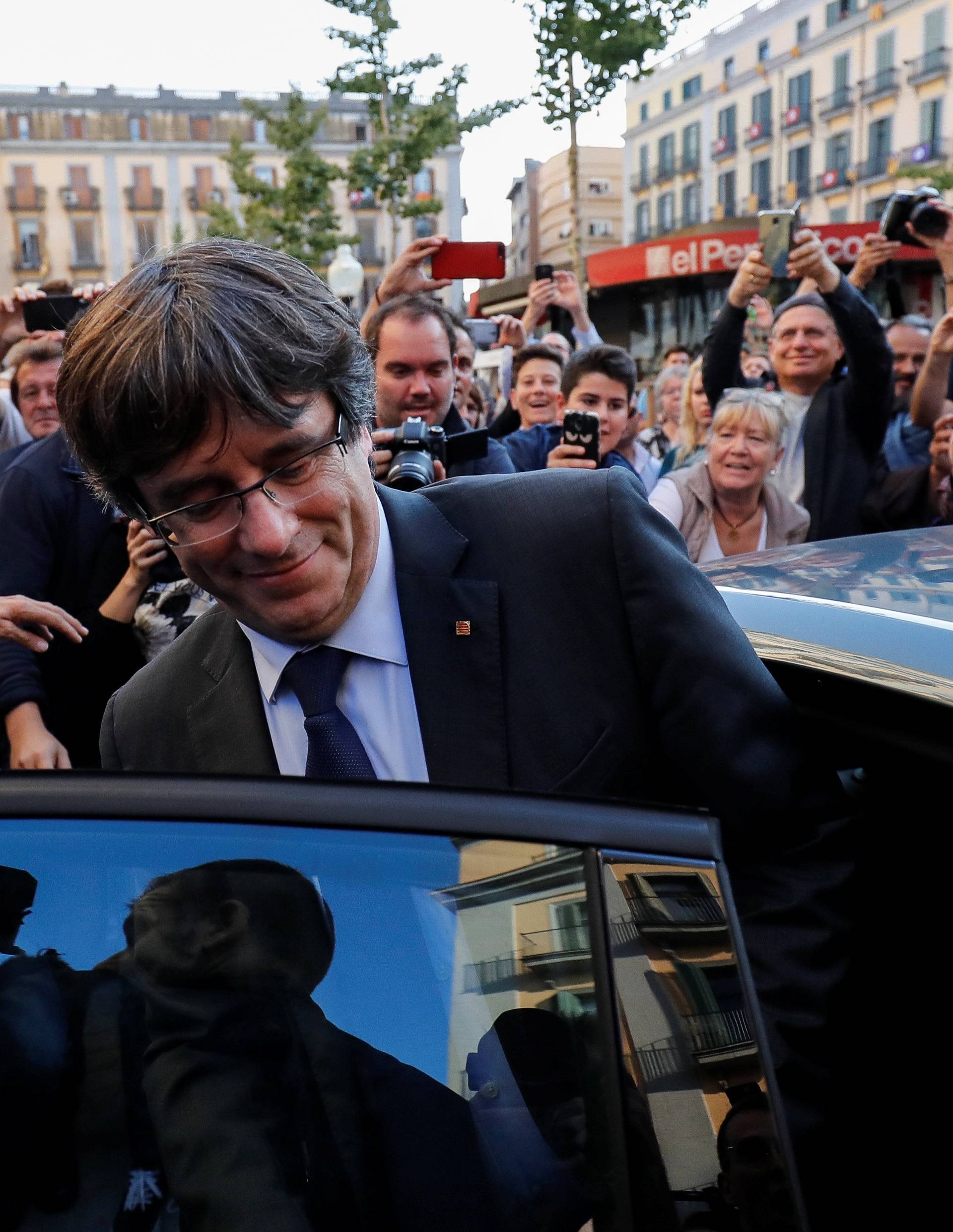 Sacked Catalan President Carles Puigdemont gets into his car after a walkabout through the center of town the day after the Catalan regional parliament declared independence from Spain in Girona