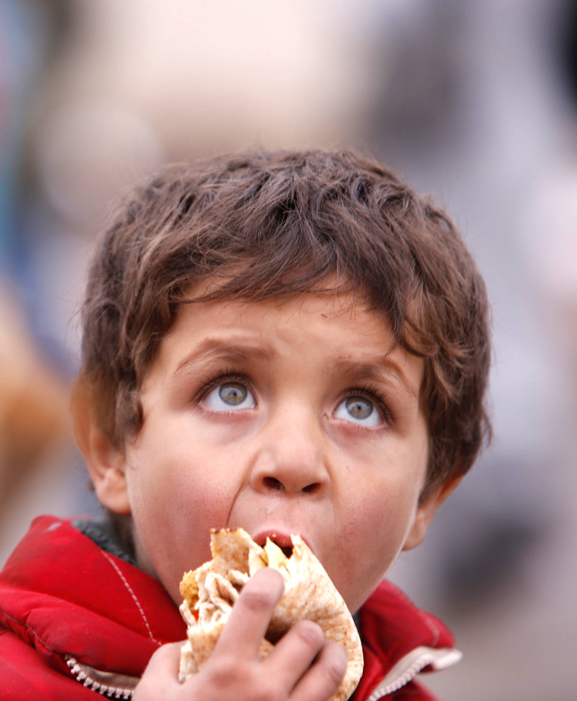 A Syrian boy evacuated from eastern Aleppo, eats bread in government controlled Jibreen area in Aleppo
