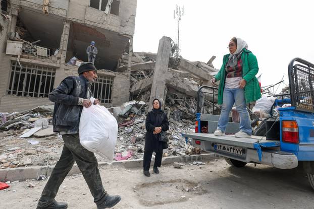 A family gathers the remaining furniture from an apartment damaged by an airstrike