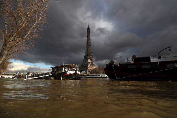 A view shows peniche houseboats moored and the Eiffel Tower along the flooded banks of the River Seine after days of almost non-stop rain caused flooding in the country in Paris