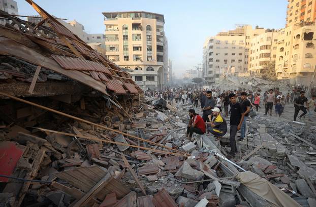 Residential building collapses after an Israeli air strike, in Gaza City