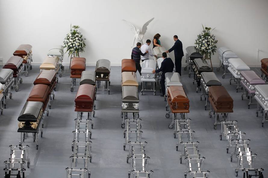 Funeral workers arrange coffins holding the remains of the victims who died in an accident of the plane that crashed into the Colombian jungle with Brazilian soccer team Chapecoense onboard, in Medellin