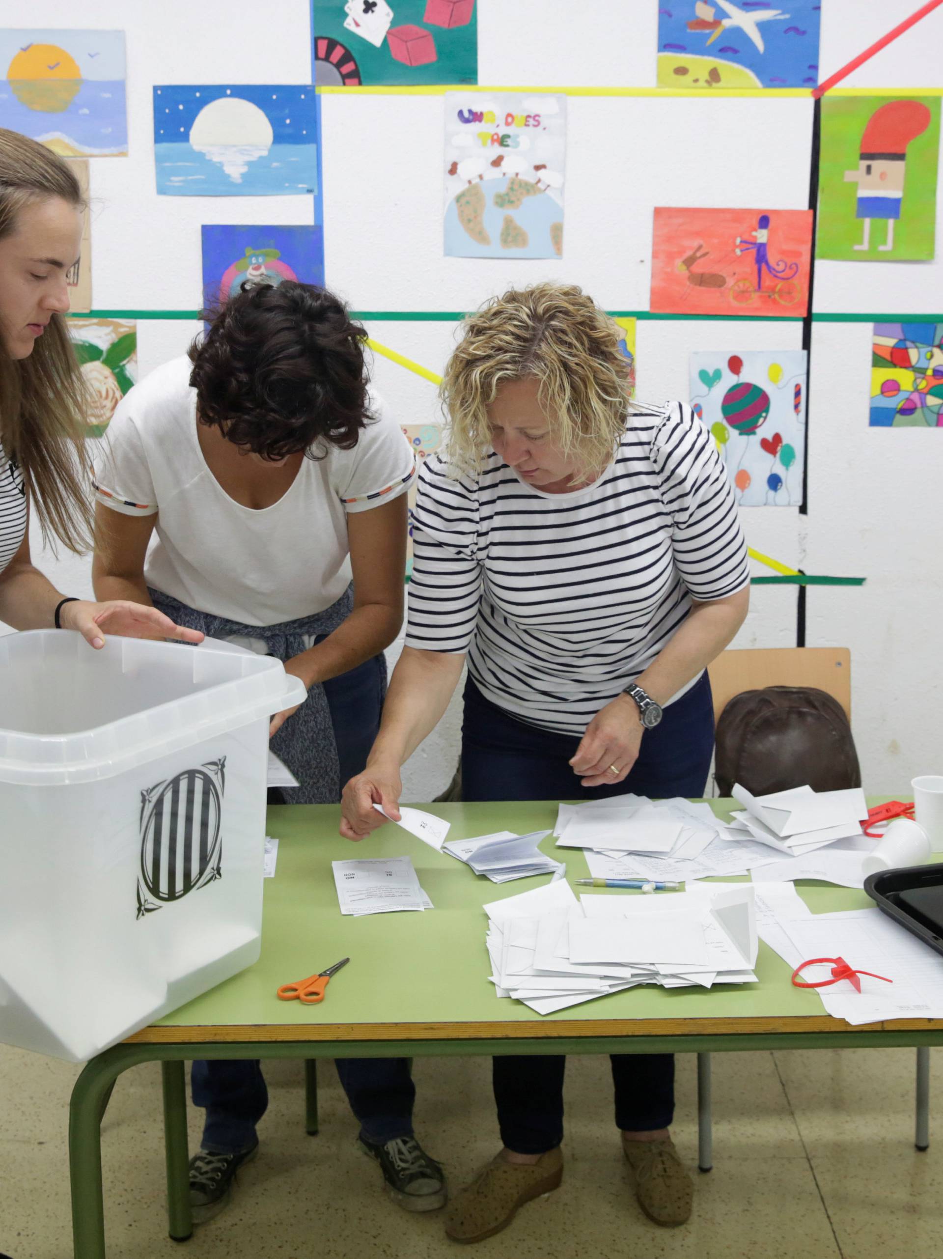 Poll workers count ballots after polls closed at a polling station for the banned independence referendum in Tarragona