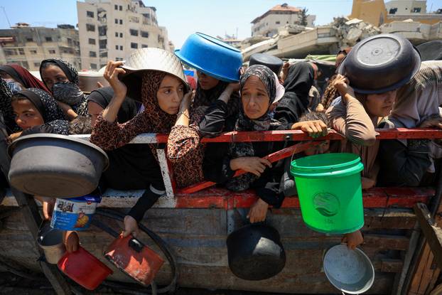 Palestinians gather to receive food from charity kitchen, in Gaza City