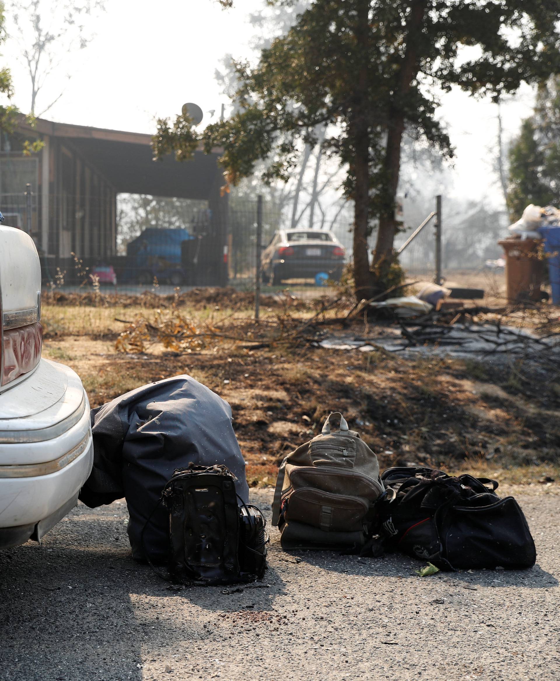 Charred luggages are seen next to a car on Quarterhorse Lane during the Clayton Fire at Lower Lake in California
