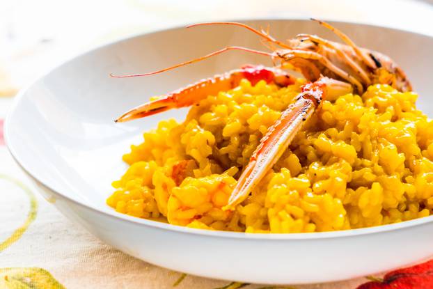 closeup of traditional saffron and shrimp italian risotto isolated on table with cloth