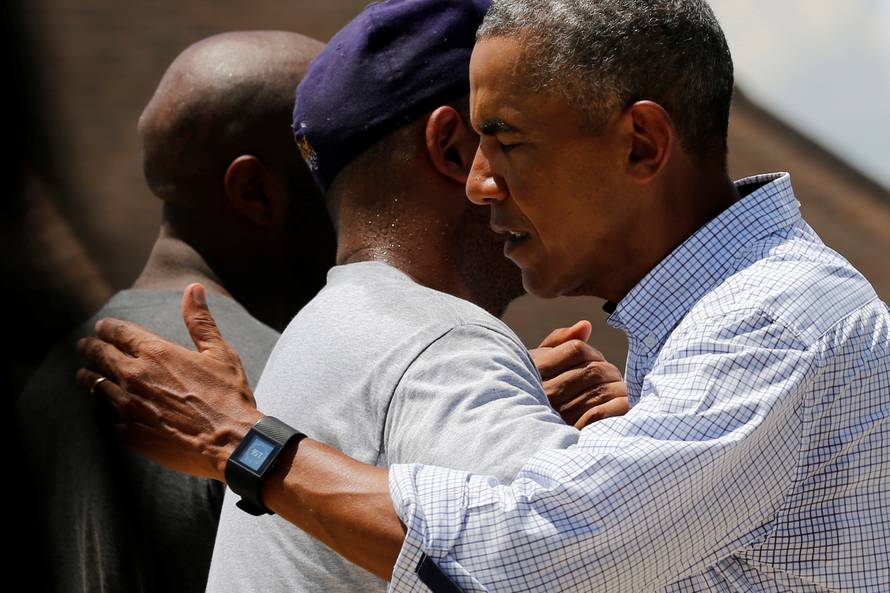 U.S. President Barack Obama greets a resident as he tours a flood-affected neighborhood in Zachary