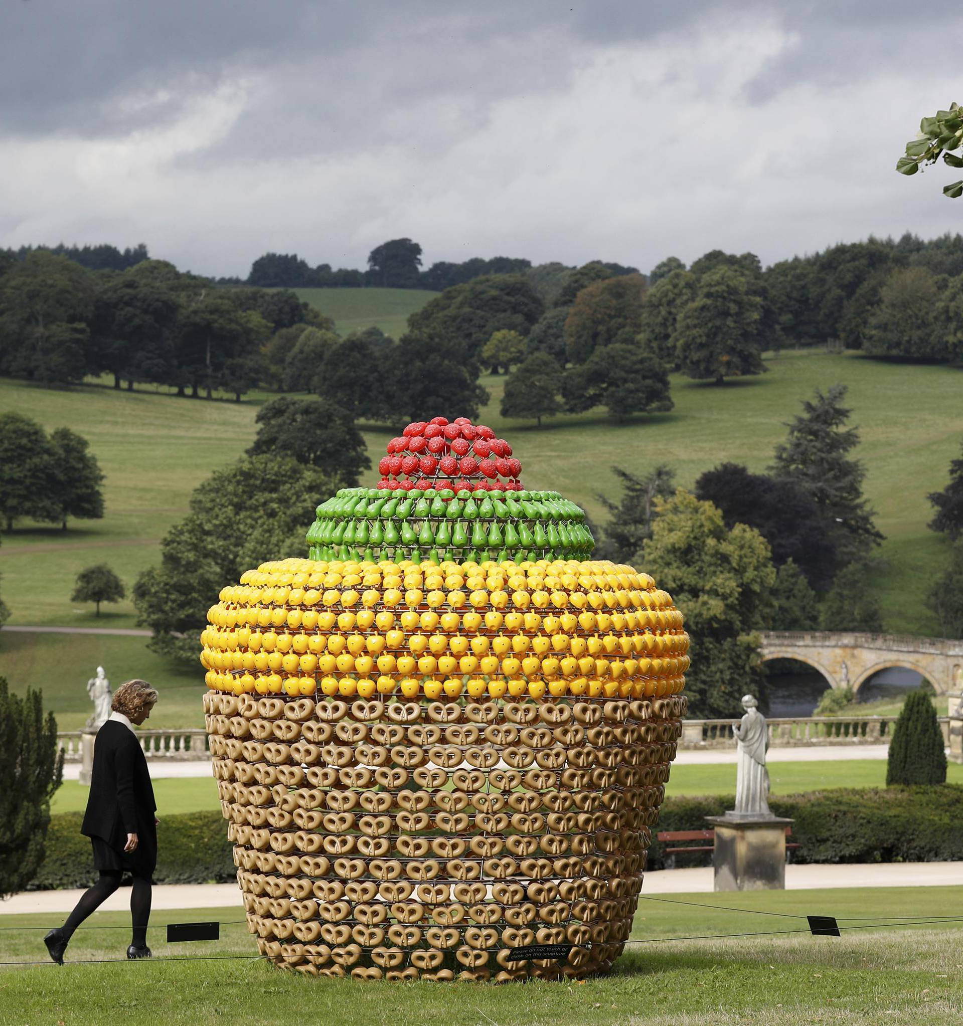 A visitor walks past a piece entitled "Fruitcake" by Joana Vasconcelo during the Beyond Limits selling exhibition at Chatsworth House