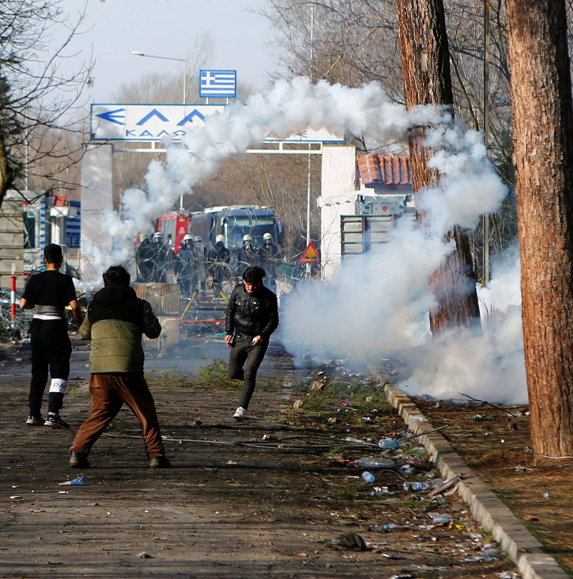 A migrant runs away from tear gas at Turkey's Pazarkule border crossing with Greece's Kastanies, near Edirne