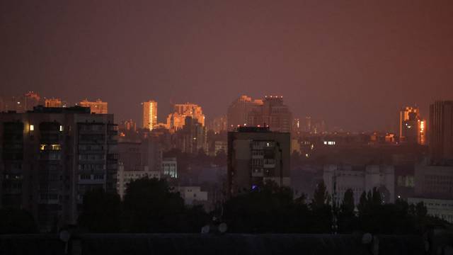A flash from the explosion of a missile illuminates the city during a Russian missile strike in Kyiv