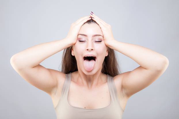 Beautiful young caucasian woman doing face yoga pose