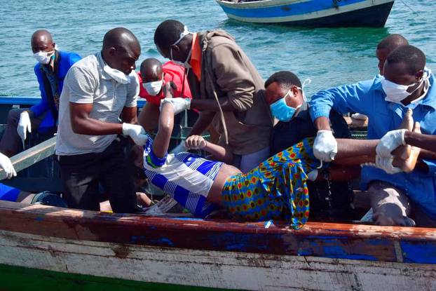 Rescue workers retrieve a body of a man from the water after a ferry overturned off the shores of Ukerewe Island on Lake Victoria