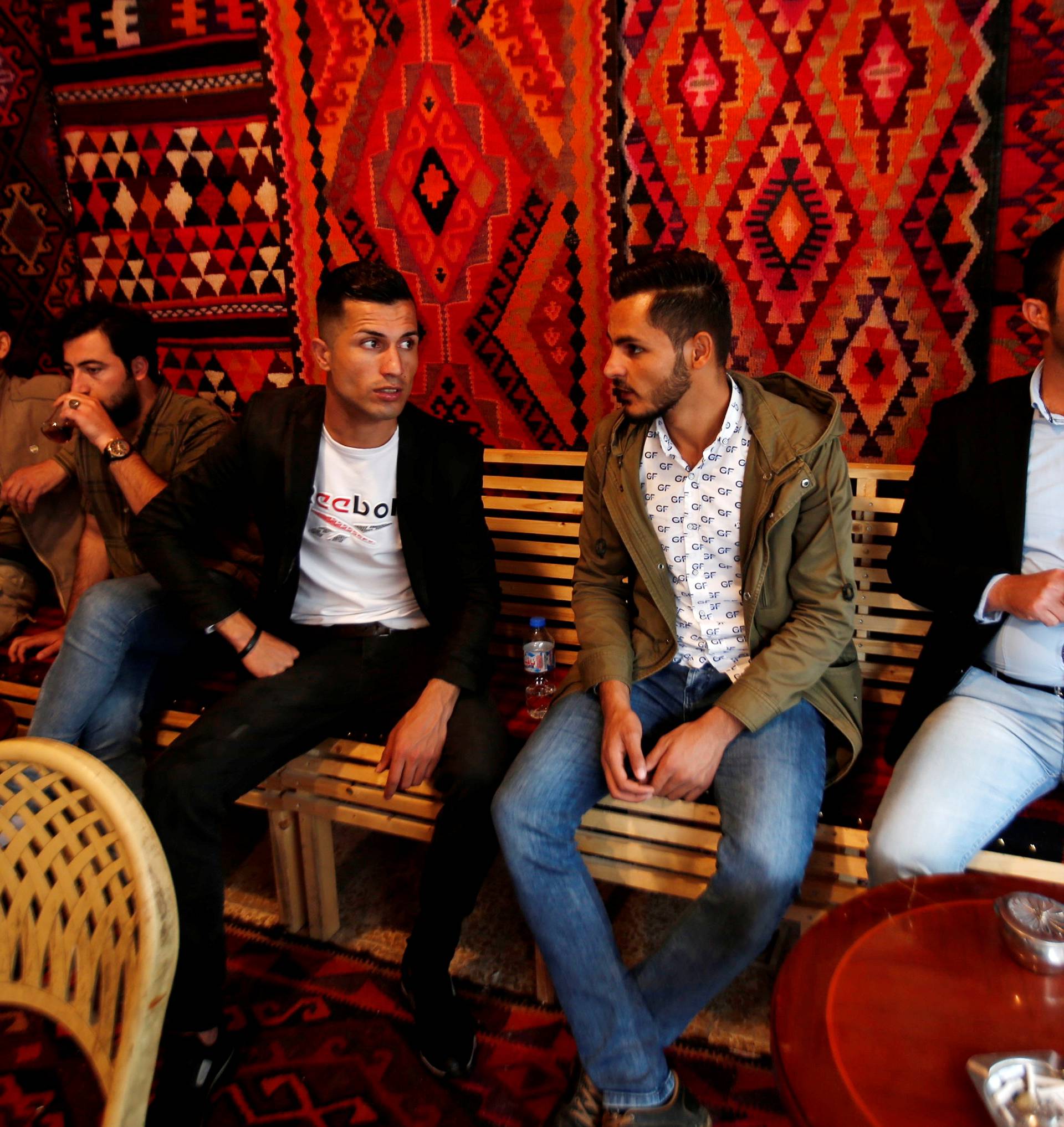 Biwar Abdullah, 25, an Iraqi Kurdish local footballer, who looks like the football player Cristiano Ronaldo, sits with his friends at a cafe in the district of Soran, northeast of Erbil