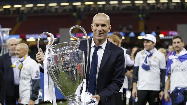 Real Madrid coach Zinedine Zidane celebrates with the trophy after winning the UEFA Champions League Final