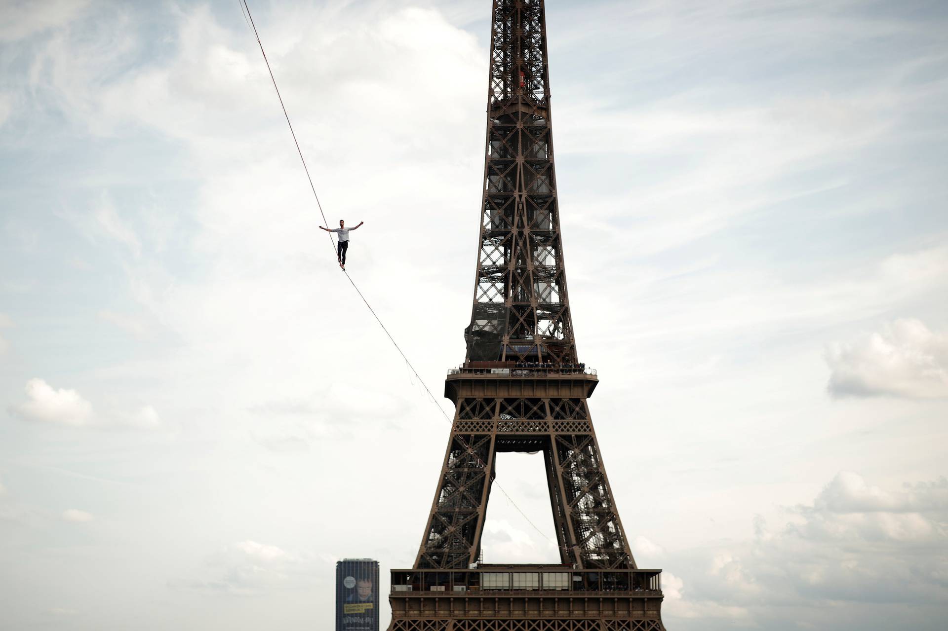 French acrobat Nathan Paulin walks on a slackline between the Eiffel Tower and the Theatre National de Chaillot as part of events around France for National Heritage Day