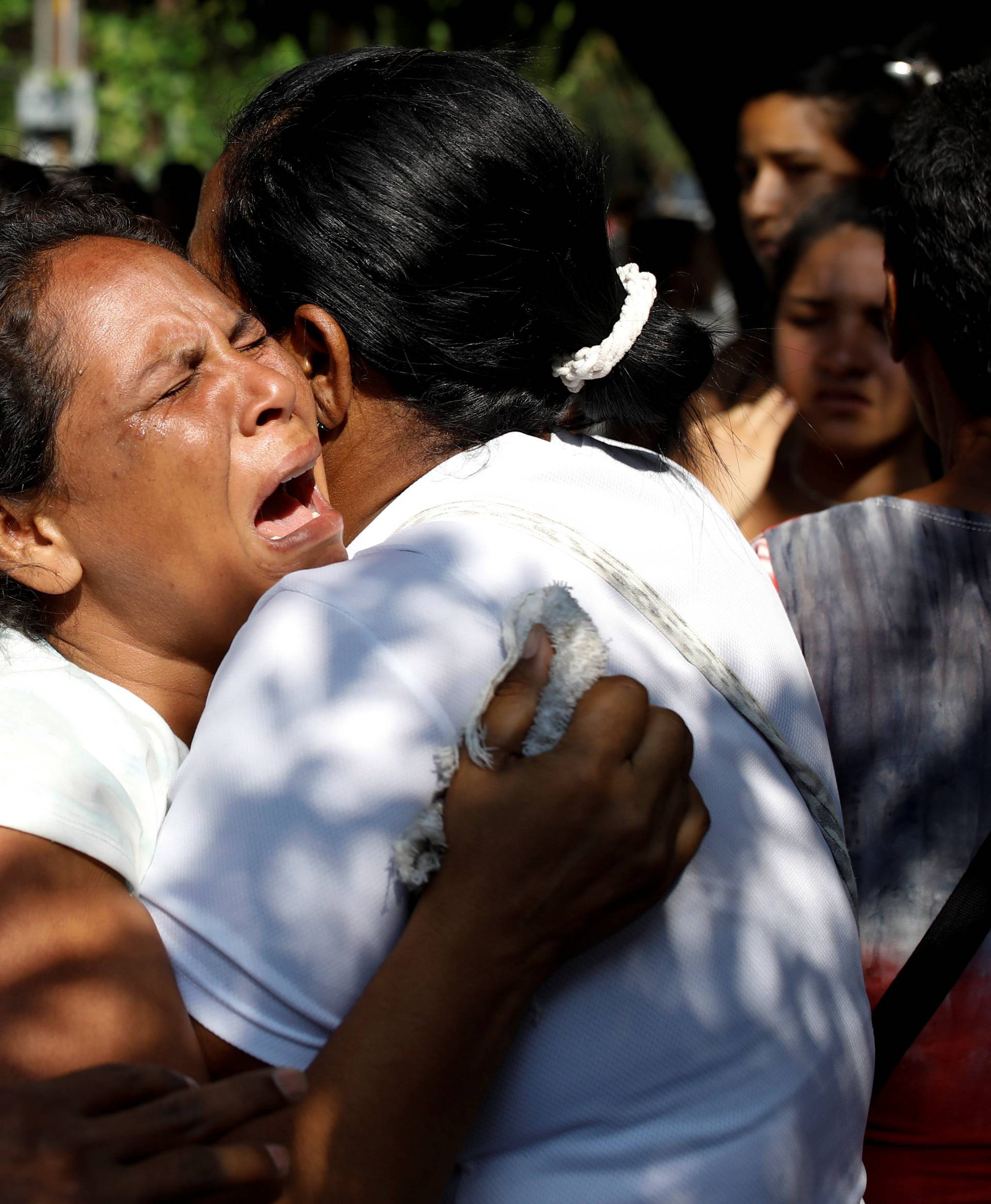Relatives of inmates held at the General Command of the Carabobo Police react as they wait outside the prison, where a fire occurred in the cells area, according to local media, in Valencia