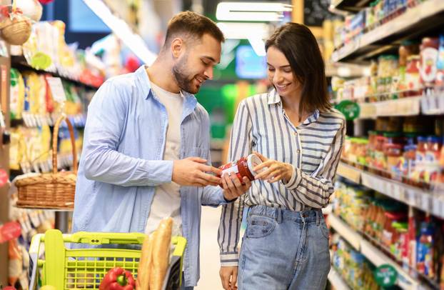 Happy couple with the cart shopping in supermarket