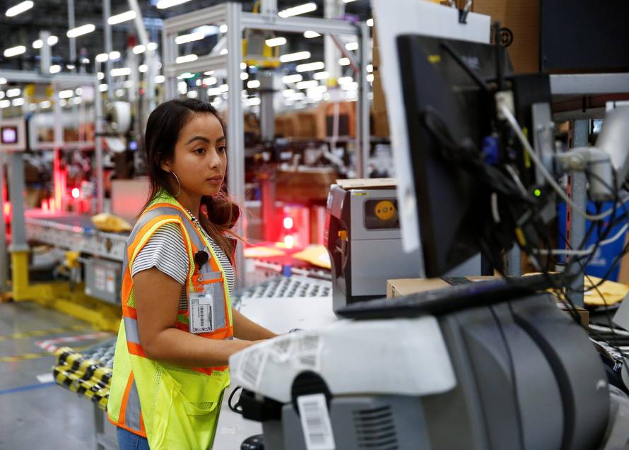 Employee Greenman works on processing packages kicked out by the automated scanning and labeling system at the Amazon fulfillment center in Kent