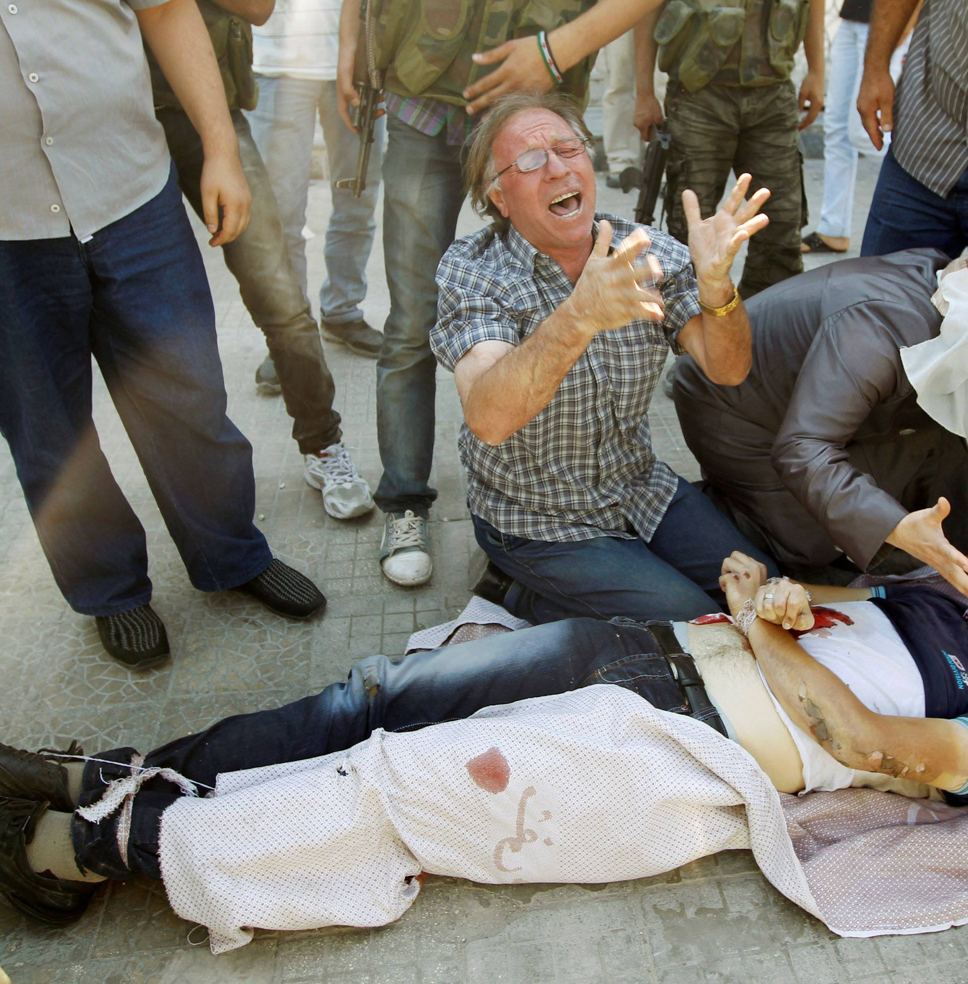 FILE PHOTO: A man and woman cry over the body of their son in Aleppo