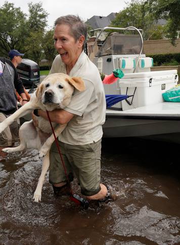Man is evacuated by boat with his dog from the Hurricane Harvey floodwaters in Houston