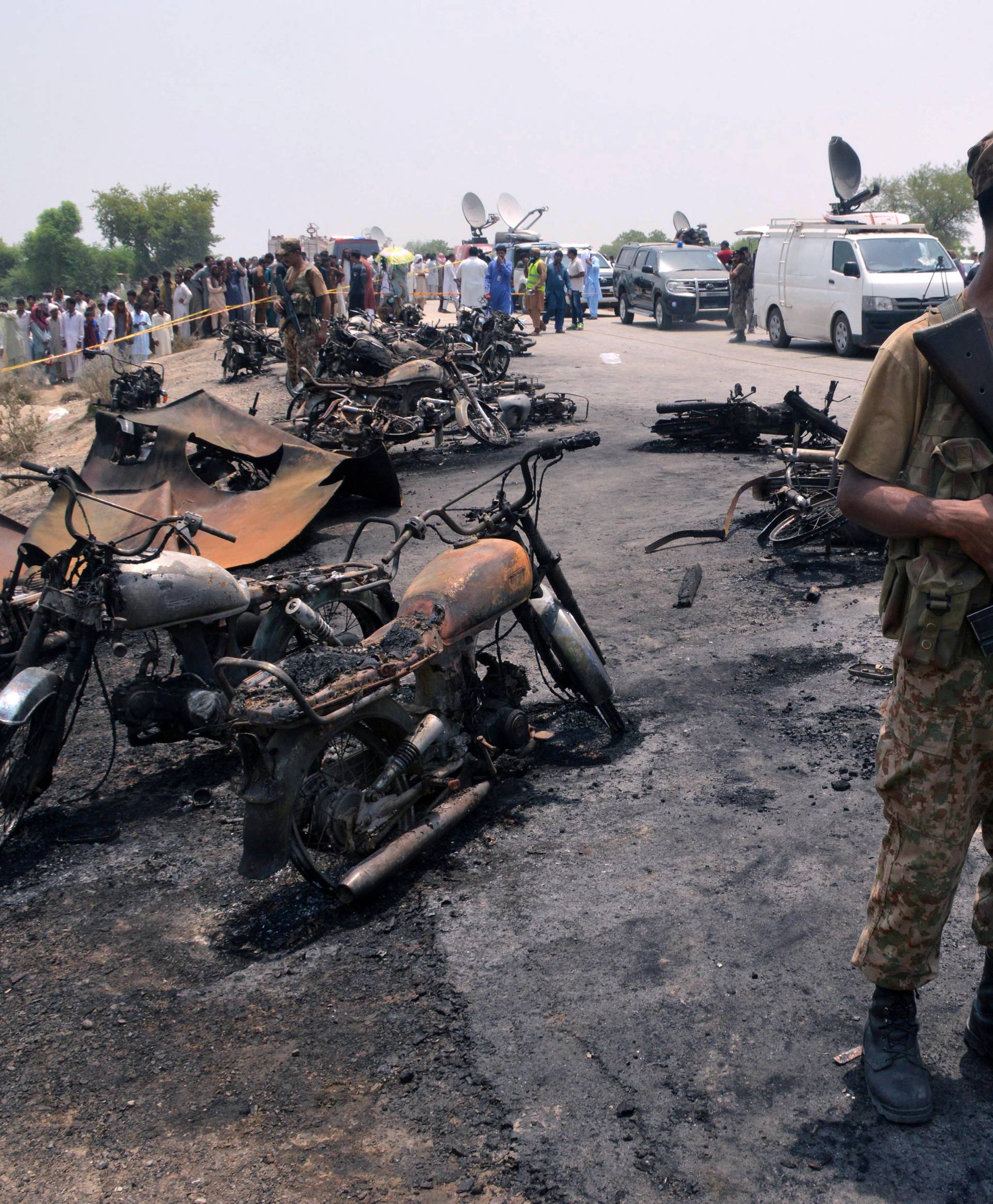 Soldier stands guard amid burnt out cars and motorcycles in Bahawalpur