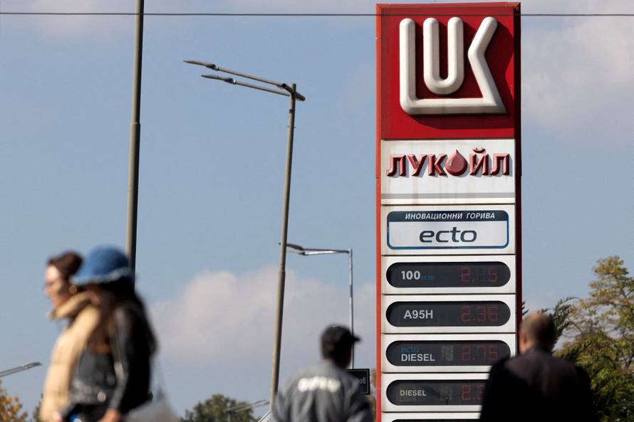 FILE PHOTO: People walk near a Lukoil gas station in Sofia