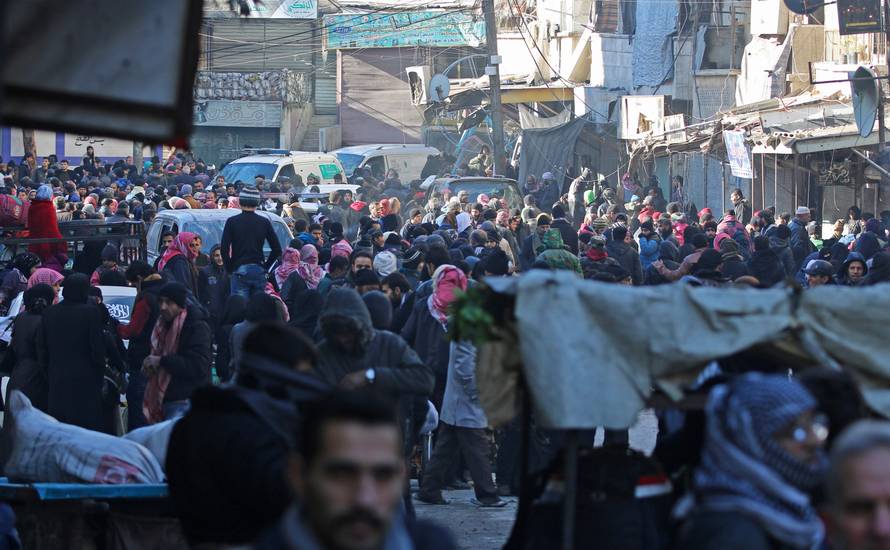 People gather to be evacuated from al-Sukkari rebel-held sector of eastern Aleppo