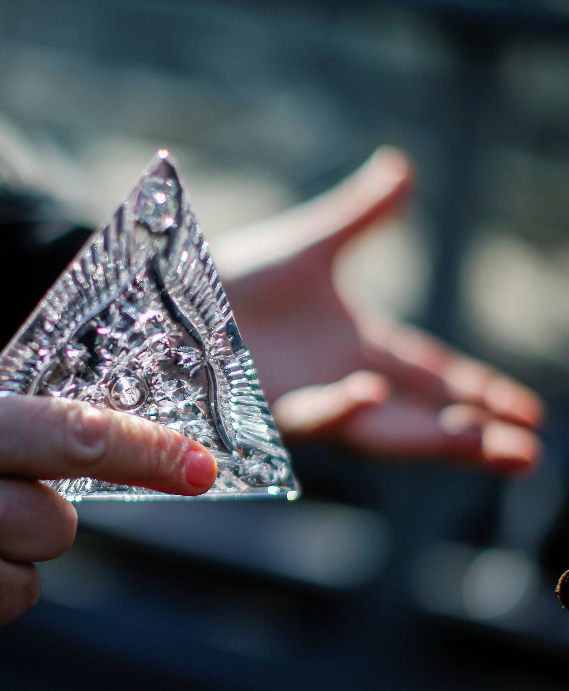 Tom Brennan, Master Artisan of Waterford Crystal, holds a Waterford Crystal triangle from the Times Square New Year's Eve Ball on the roof of One Times Square in Manhattan, New York