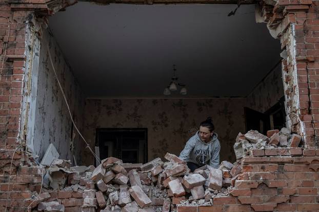 A local resident is seen at her house damaged by a Russian air strike near the Russian border in Sumy region