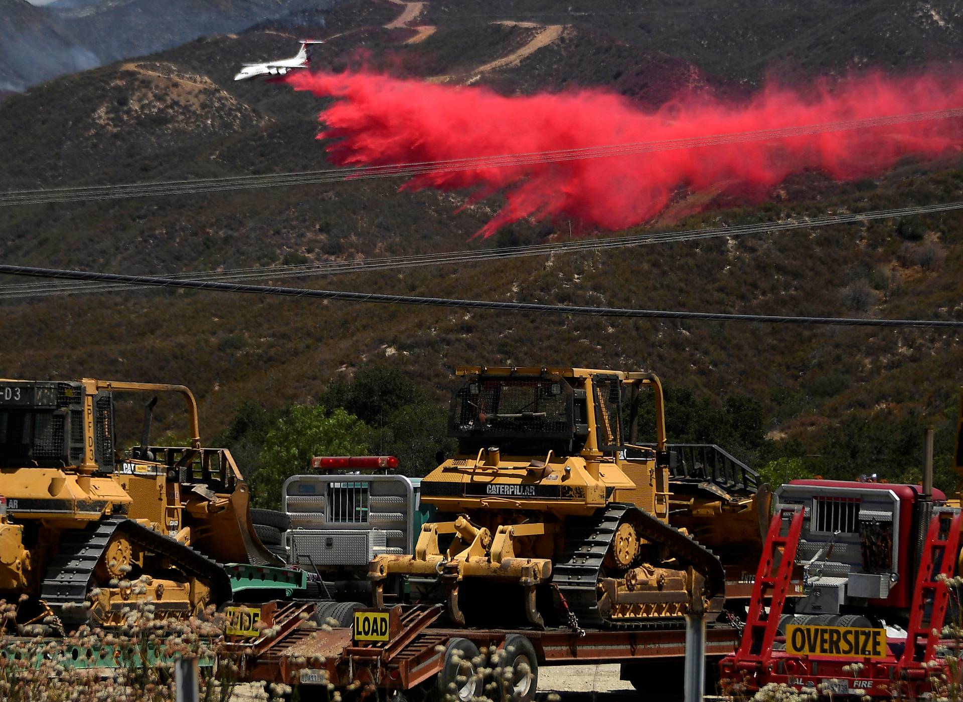 A fire fighting aircraft makes a retardant drop as fire fighters continue to battle the so-called Sand Fire in the Angeles National Forest near Los Angeles, California