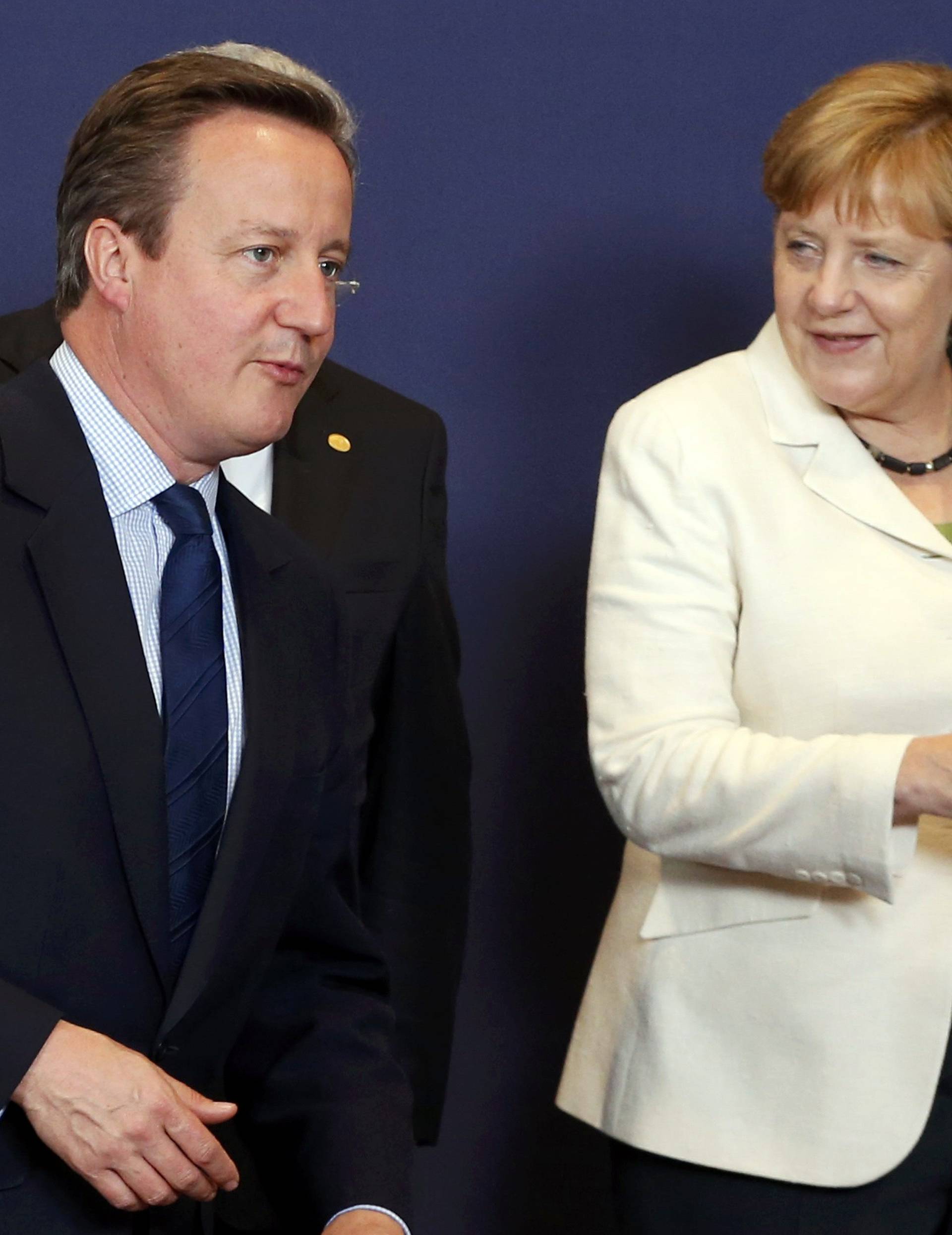 British PM Cameron and German Chancellor Merkel take place for the traditional family photo at he EU summit in Brussels
