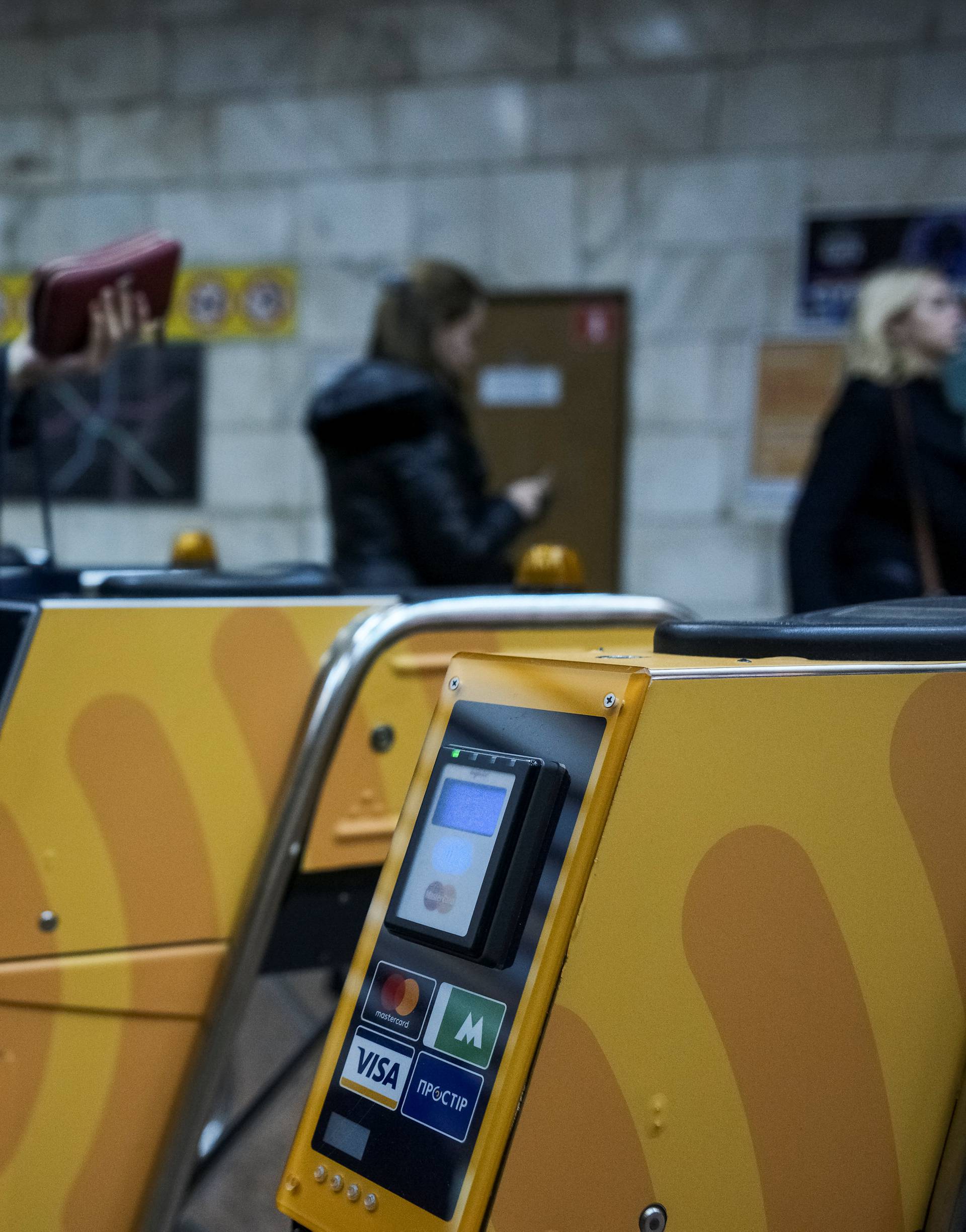A passenger swipes a card against a terminal to ride the subway system in Kiev