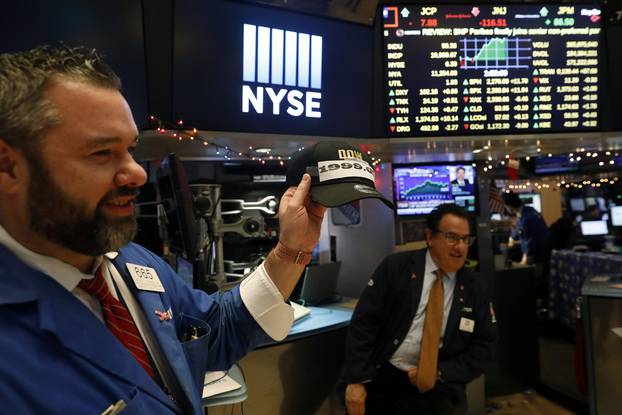 A trader laughs as he holds a hat at NYSE