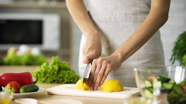 Female,Chef,Cutting,Lemon,With,Sharp,Knife,For,Lunch,Preparing,