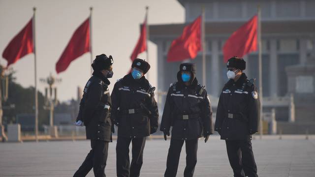 Police officers wearing masks are seen at at the Tiananmen Square, as the country is hit by an epidemic of the new coronavirus, in Beijing