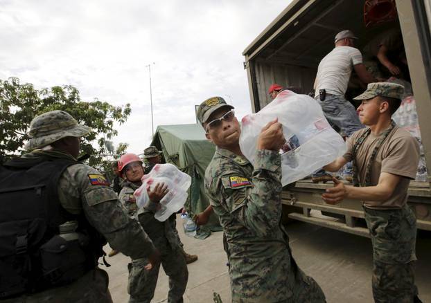 Soldiers carry water from a truck after an earthquake struck the town of Canoa in Ecuador