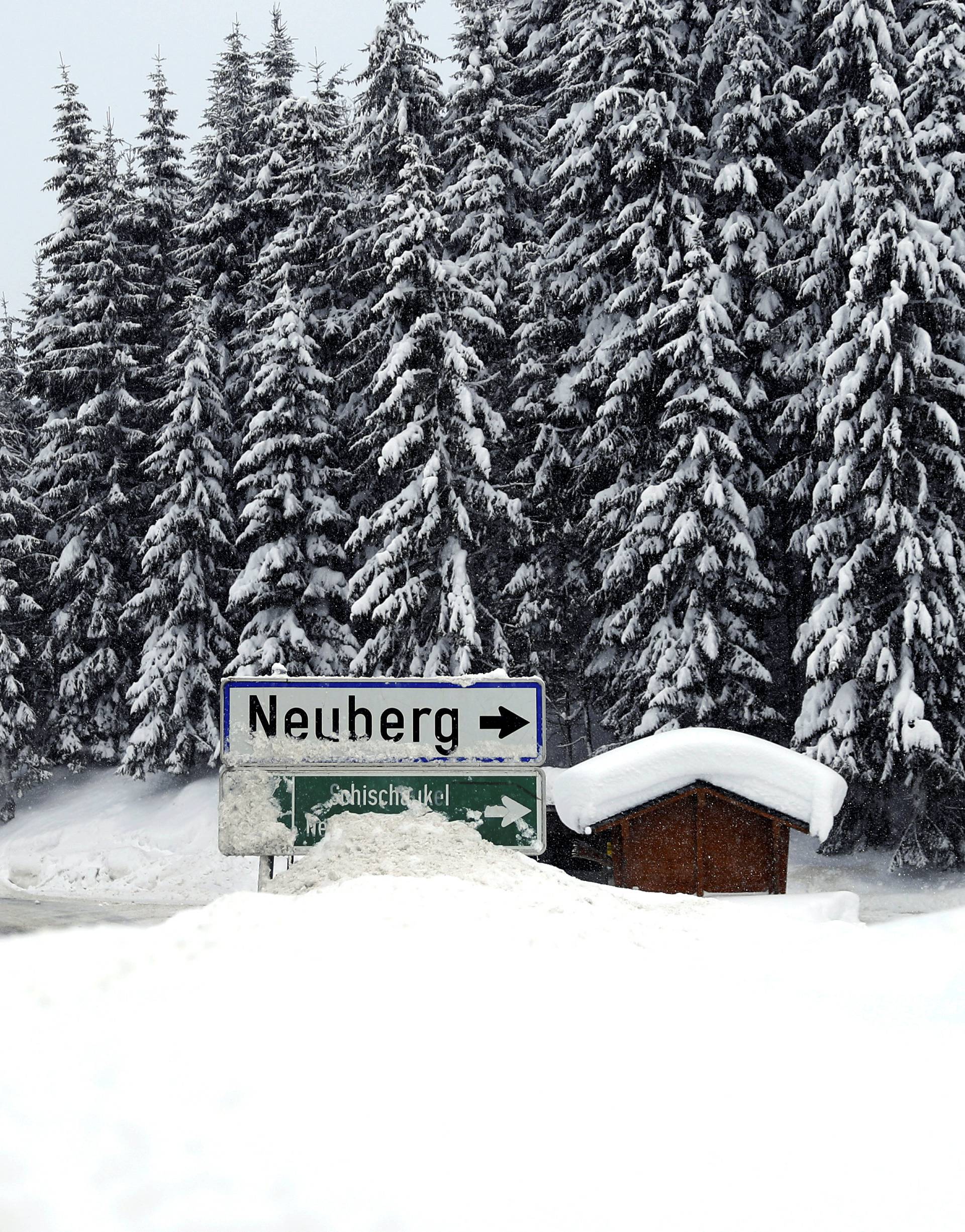 A car is seen on a road during heavy snowfall in Filzmoos