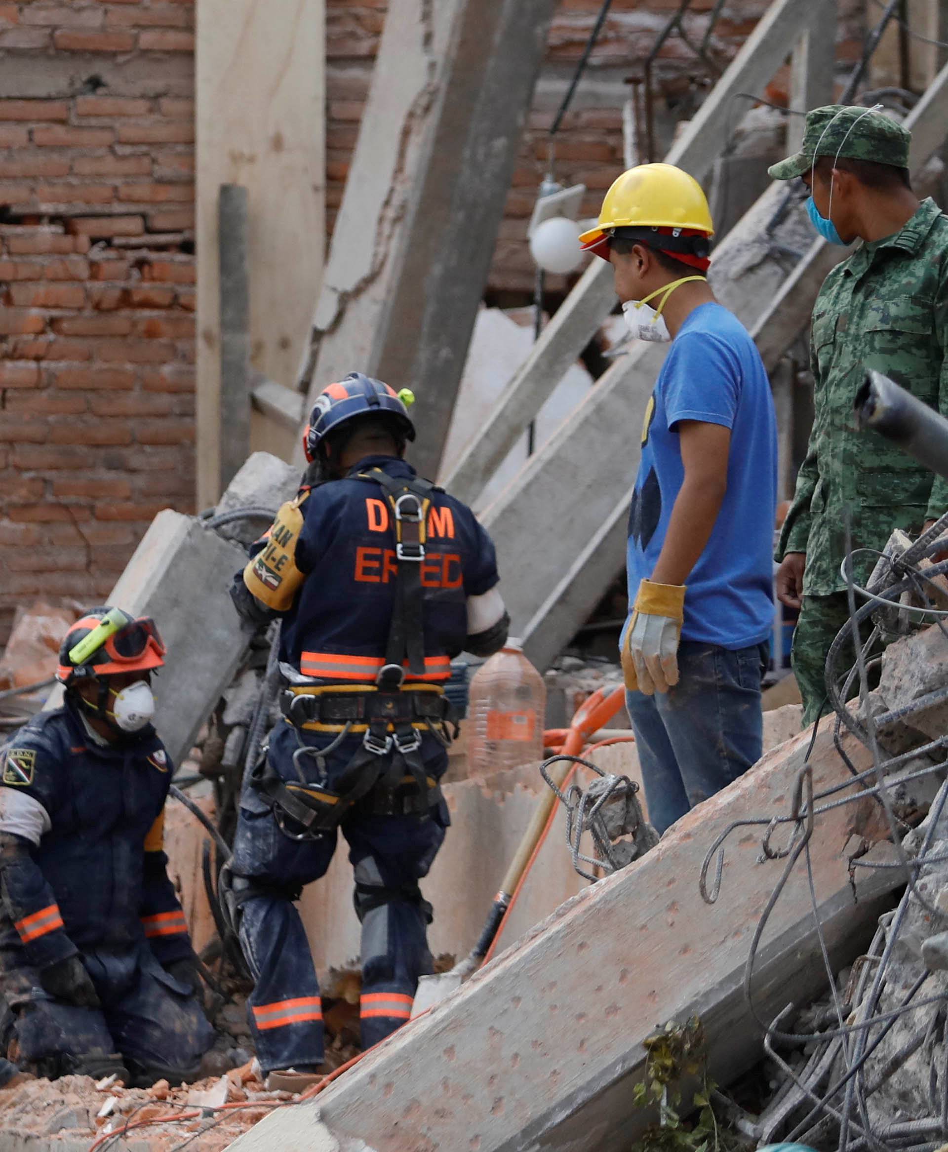 Rescue workers search through the rubble for students at Enrique Rebsamen school in Mexico City