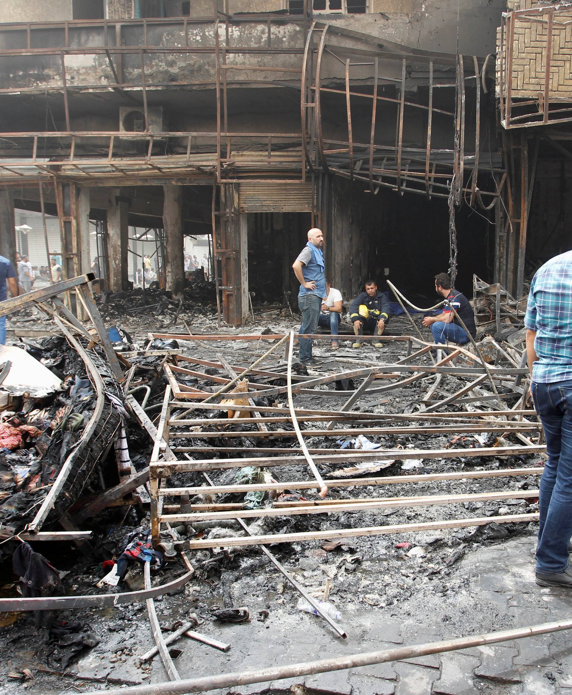 Iraqi security forces and civilians gather at the site after a suicide car bomb occurred in the Karrada shopping area in Baghdad, Iraq