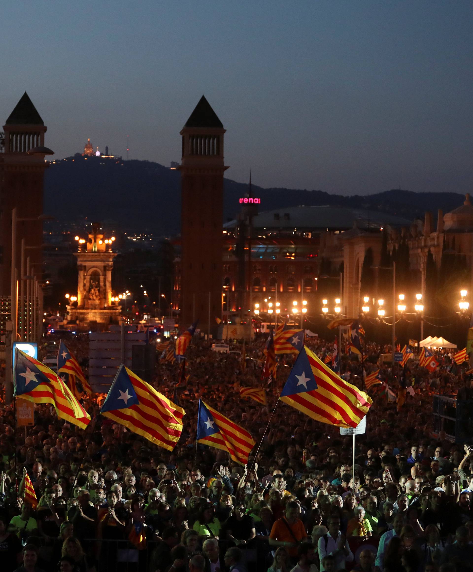 People wave Esteladas (Catalan separatist flags) as they attend a closing rally in favour of the banned October 1 independence referendum in Barcelona