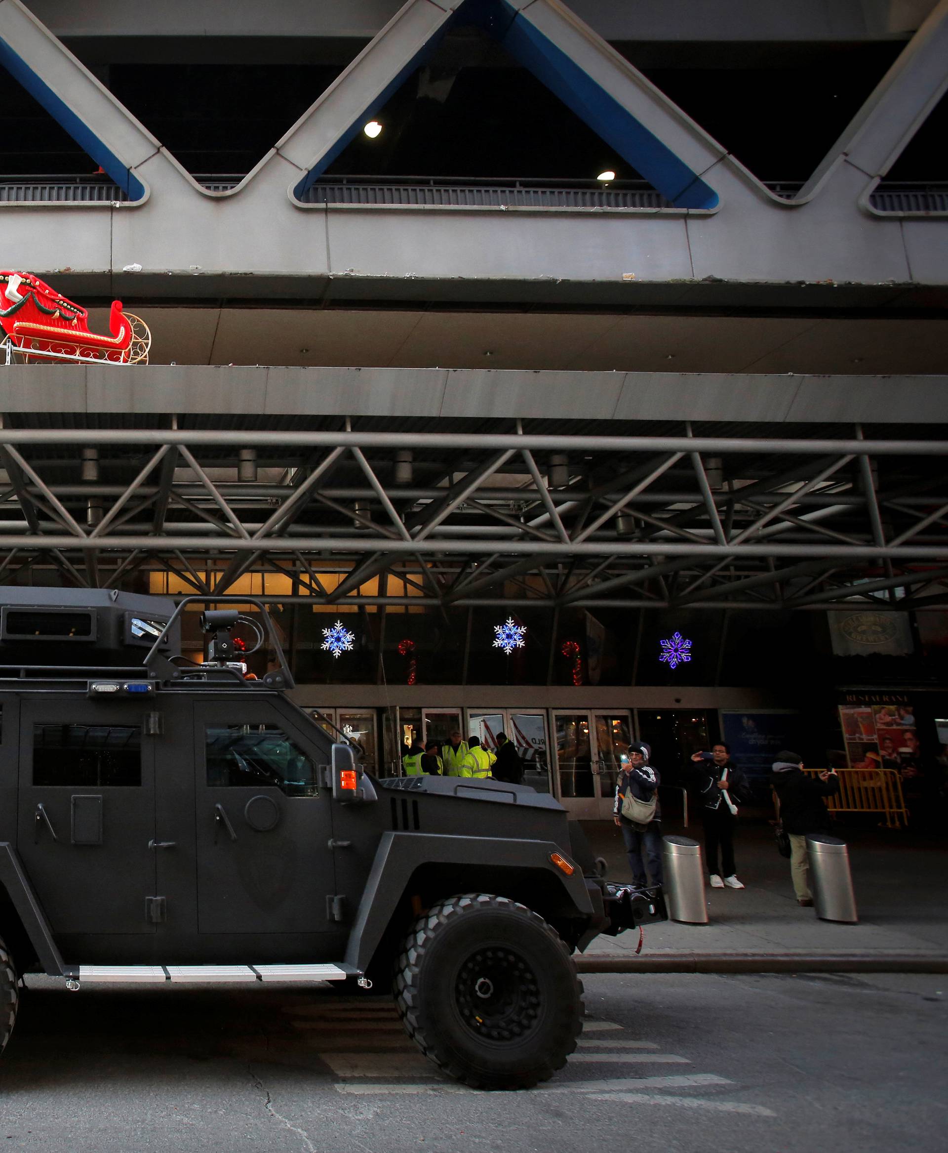 An armored vehicle belonging to the New York Port Authority sits beneath a Christmas decoration at the entrance of the New York Port Authority Bus Terminal following an attempted detonation during the morning rush hour, in New York City